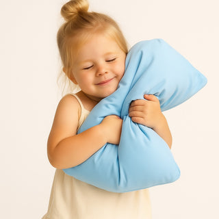 Toddler holding a washable cot pillow for toddlers in daycare, made with cloud-soft bamboo fabric by Claire De Lune Cloud Co.